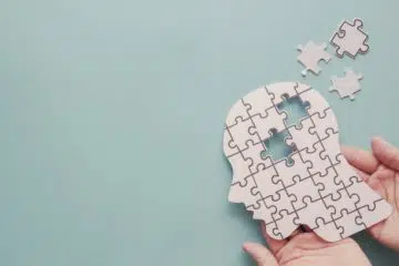 Hands holding brain with puzzle paper 