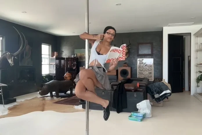 Doja Cat spins on pole while reading a book