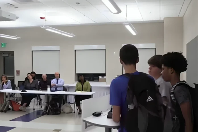 Students call out their teacher during a school board meeting for supporting the violence