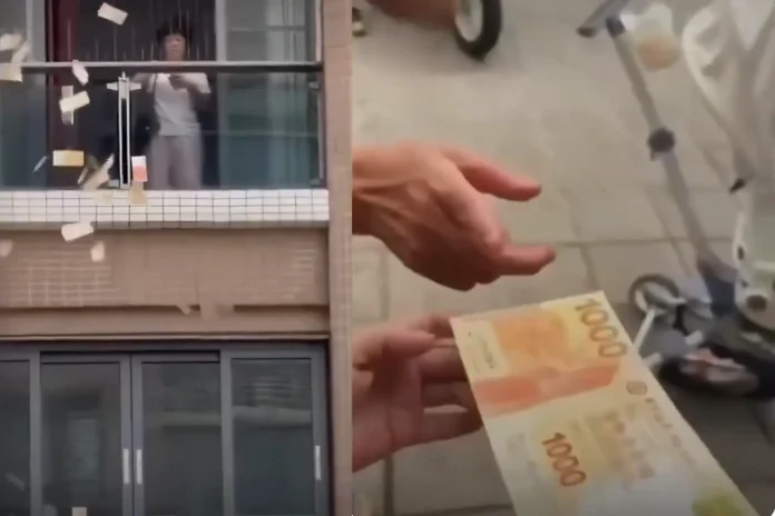 woman throws money from balcony